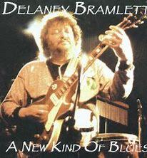 Album cover of "DELANEY BRAMLETT - A NEW KIND OF BLUES" by Delaney Bramlett, featuring him playing guitar on stage, now available as a rare and collectable preowned CD.