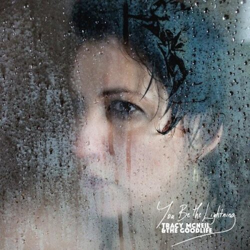 A woman's face partially obscured by a rain-spattered window, evoking a contemplative or melancholic mood on the Gold Coast.