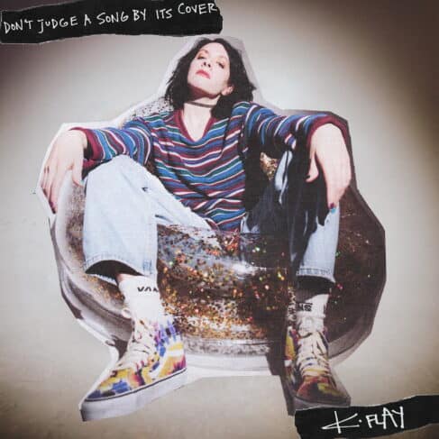 A person wearing a striped long-sleeve shirt, blue jeans, and colorful patterned Vans shoes is sitting with their knees up and arms draped over them. Above, the text reads "Don't judge a song by its cover," accompanied by "K.Flay" in the bottom right, reminiscent of classic vinyl records cover art.