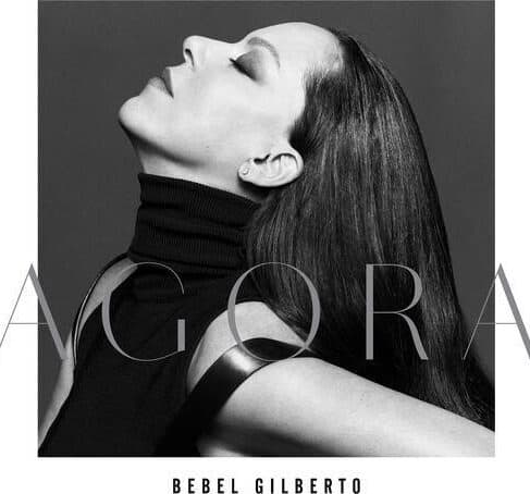 A black-and-white image of a woman with long hair, leaning her head back with her eyes closed. She wears a sleeveless, high-neck top. The word "AGORA" is displayed prominently in large letters, and "BEBEL GILBERTO" is written at the bottom, capturing the essence of classic vinyl records: **BEBEL GILBERTO - AGORA (VINYL LP)**.